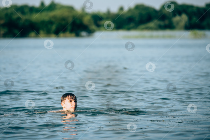 Скачать Мальчик купается в озере летом-вид сзади фотосток Ozero