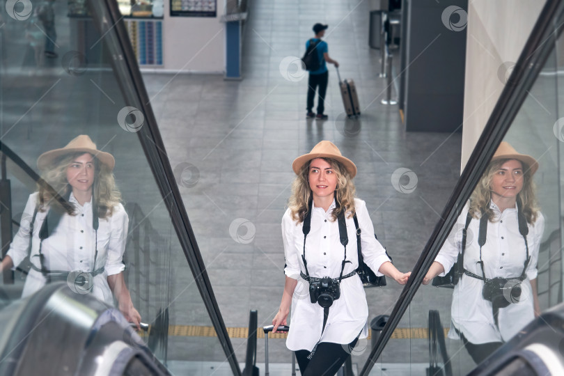 Скачать женщина-путешественница поднимается по эскалатору в аэропорту фотосток Ozero