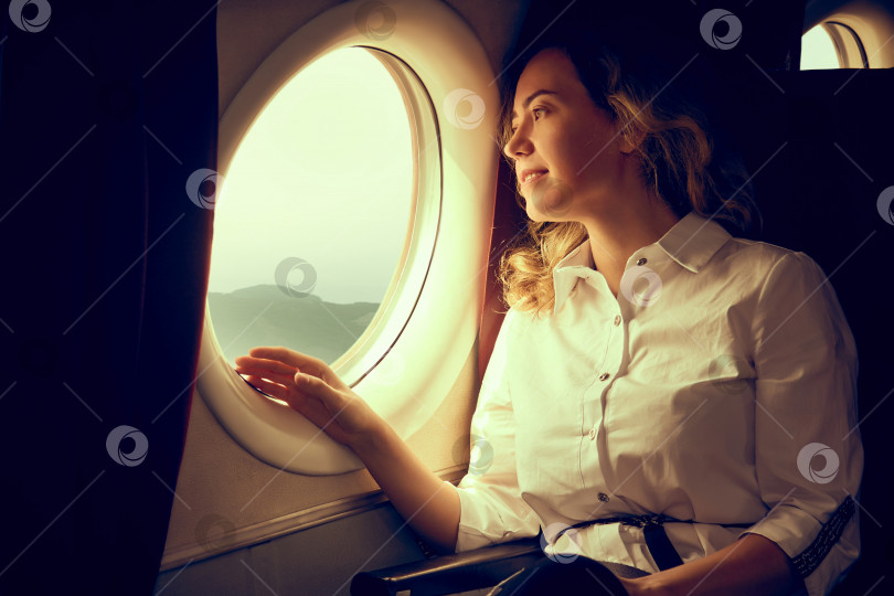 Скачать женщина летит в качестве пассажира в самолете, фото в золотистых тонах фотосток Ozero