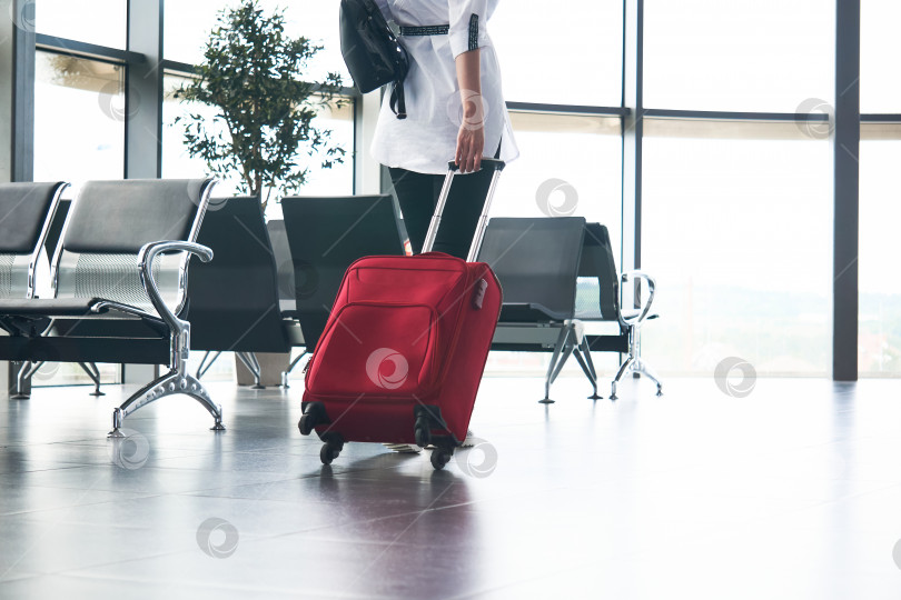 Скачать женщина-путешественница с багажом в зале ожидания аэропорта или железнодорожного вокзала; ноги и чемодан крупным планом фотосток Ozero