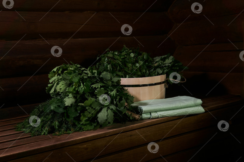 Скачать интерьер традиционной паровой сауны-бани с деревянной ванной, простынями или полотенцами и банными вениками на скамейке фотосток Ozero