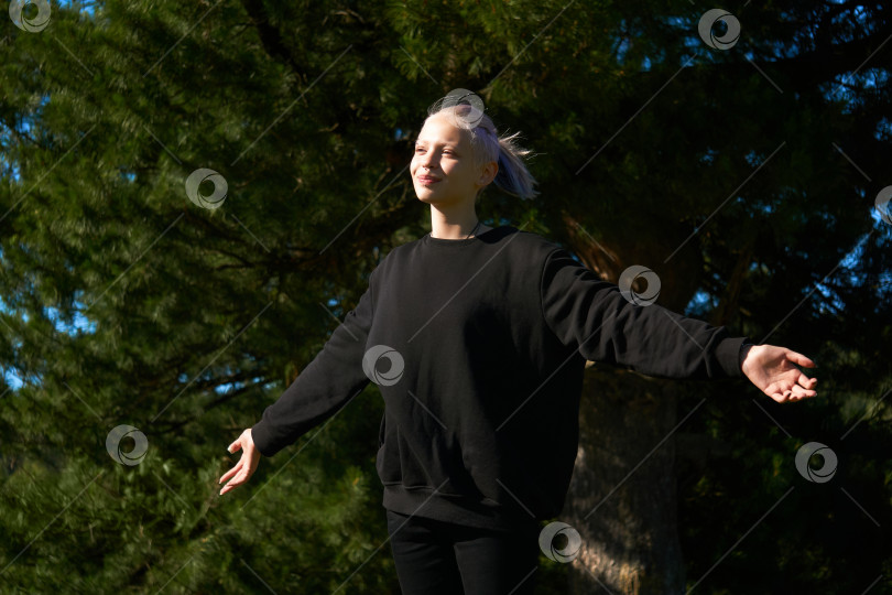 Скачать девочка-подросток радуется солнцу и ветру на фоне большого дерева фотосток Ozero