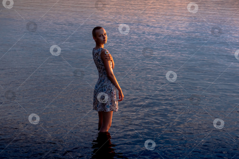 Скачать девочка-подросток в платье у моря входит в воду фотосток Ozero