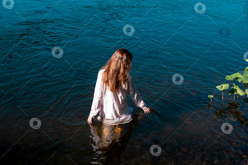 Скачать молодая женщина купается в реке, наслаждаясь прохладной водой фотосток Ozero