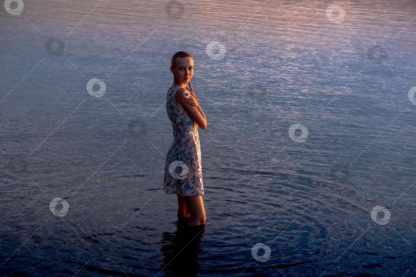 Скачать девочка-подросток в платье у моря входит в воду фотосток Ozero