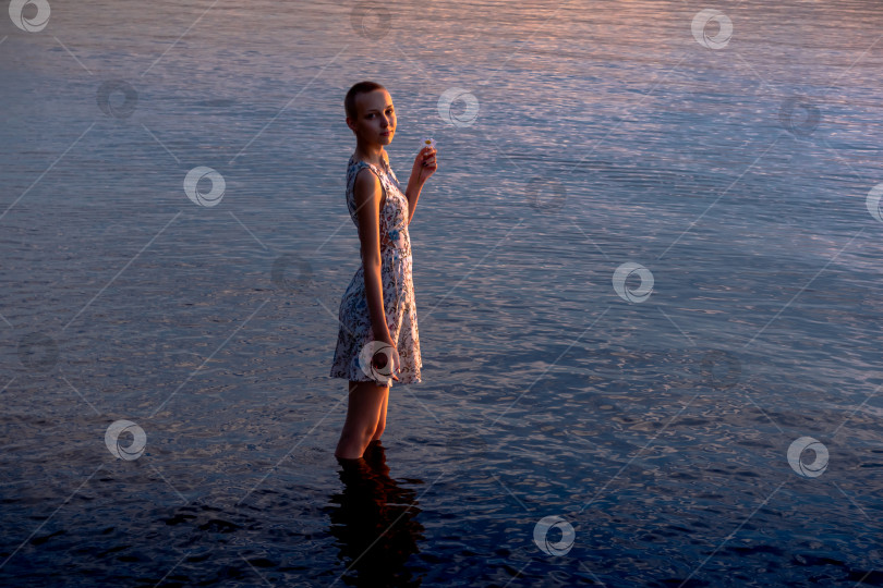 Скачать девочка-подросток в платье у моря входит в воду фотосток Ozero