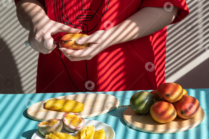 Скачать шеф-повар режет фрукты. Женские руки режут манго и маракуйю, фруктовый завтрак фотосток Ozero