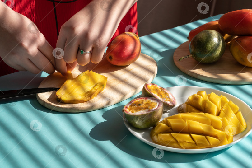 Скачать шеф-повар режет фрукты. Женские руки режут манго и маракуйю, фруктовый завтрак фотосток Ozero