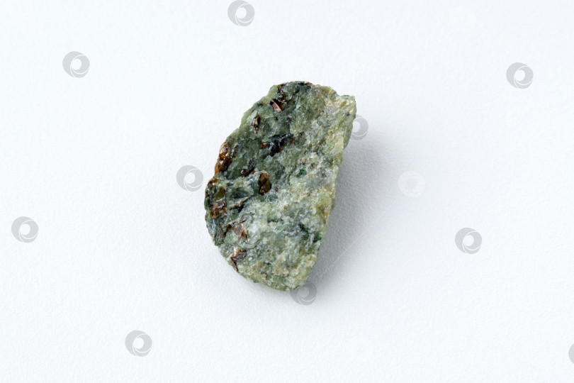 Скачать Натуральный хризолит, оливиново-зеленый цвет, прозрачный необработанный кристалл, крупный план, белый фон фотосток Ozero