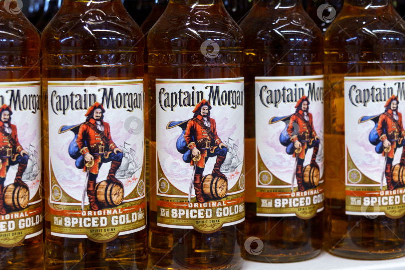 Скачать Тюмень, Россия - 17 марта 2023 года: оригинальные бутылки для спиртных напитков Captain Morgan spiced gold spirit. На полках гипермаркетов фотосток Ozero