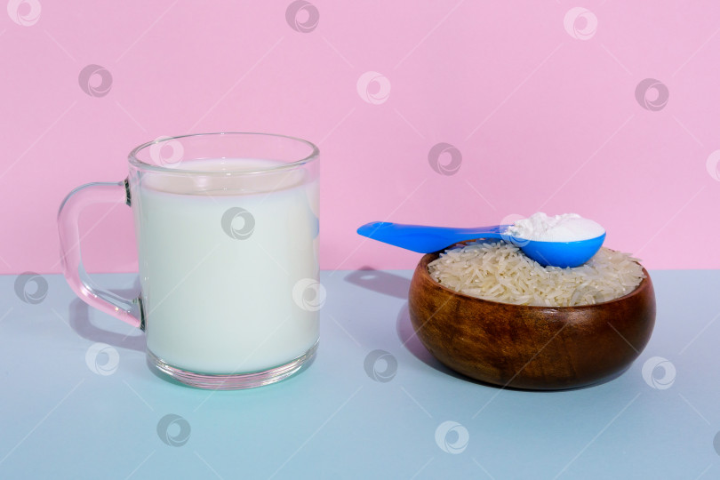 Скачать Сухое вегетарианское молоко, приготовленное из риса, на розово-голубом фоне. фотосток Ozero