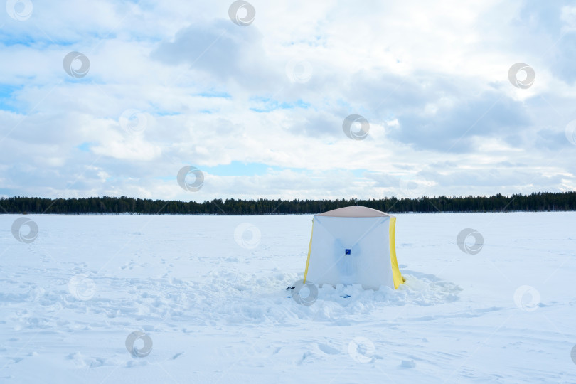 Скачать Палатка в снегу на замерзшей реке зимним днем. Рыболовная палатка фотосток Ozero