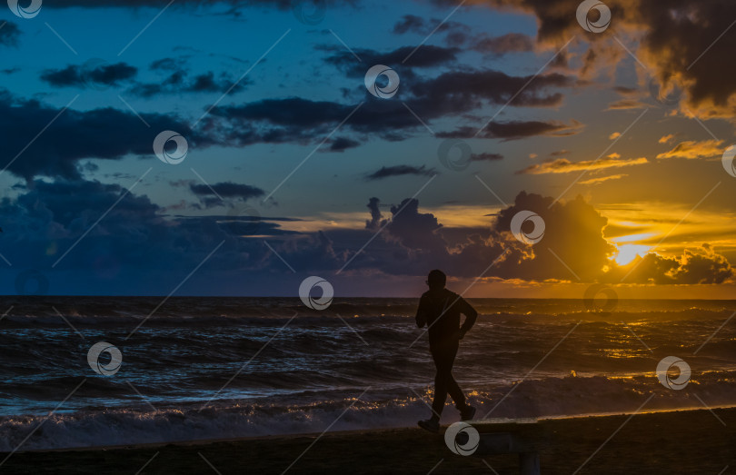 Скачать Фотография человека, бегущего по пляжу на закате недалеко от Рима, Италия фотосток Ozero
