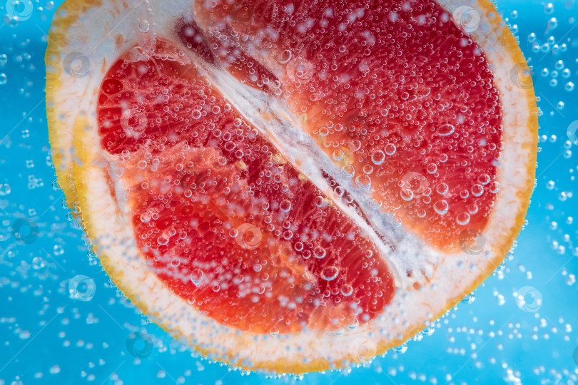 Скачать Грейпфрут крупным планом, под водой, для получения сока. Спелый сочный фрукт в воде фотосток Ozero
