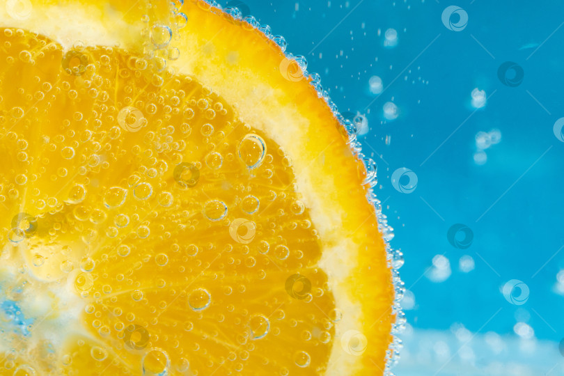 Скачать оранжевый фрукт в воде крупным планом. Освежающий грейпфрутовый напиток, коктейль. фотосток Ozero
