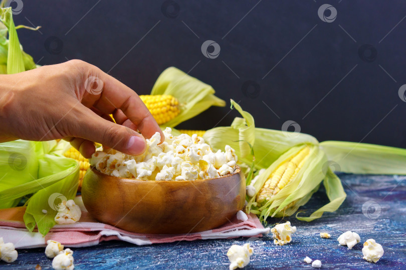 Скачать Попкорн на столе со свежей кукурузой на черном темном фоне. Копировальное пространство фотосток Ozero