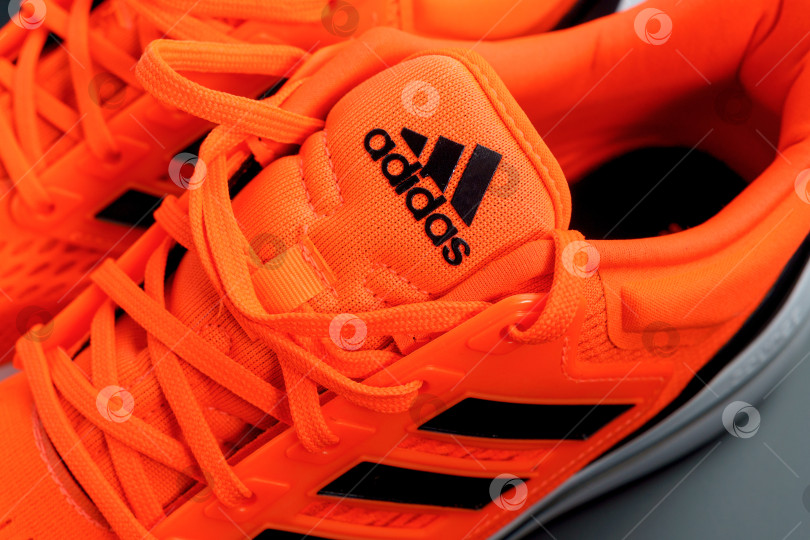 Скачать Тюмень, Россия - 13 ноября 2021 года: Новые кроссовки Adidas оранжевого цвета. Модель изготовлена из переработанных материалов фотосток Ozero