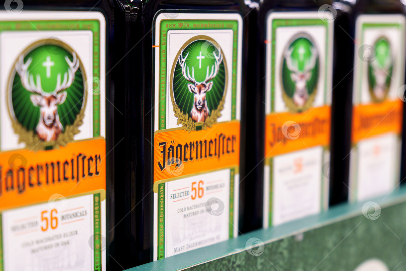 Скачать Тюмень, Россия - 02 декабря 2021 года: этикетка Jagermeister на многих рядах бутылок в магазине. Избирательный фокус. На полках гипермаркетов фотосток Ozero