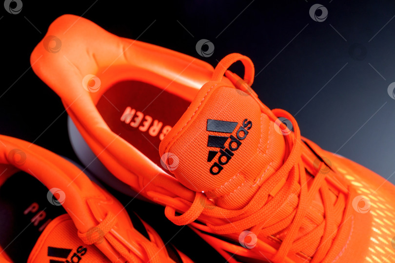 Скачать Тюмень, Россия - 13 ноября 2021 года: логотип Adidas на оранжевых кроссовках крупным планом. Избирательный фокус фотосток Ozero