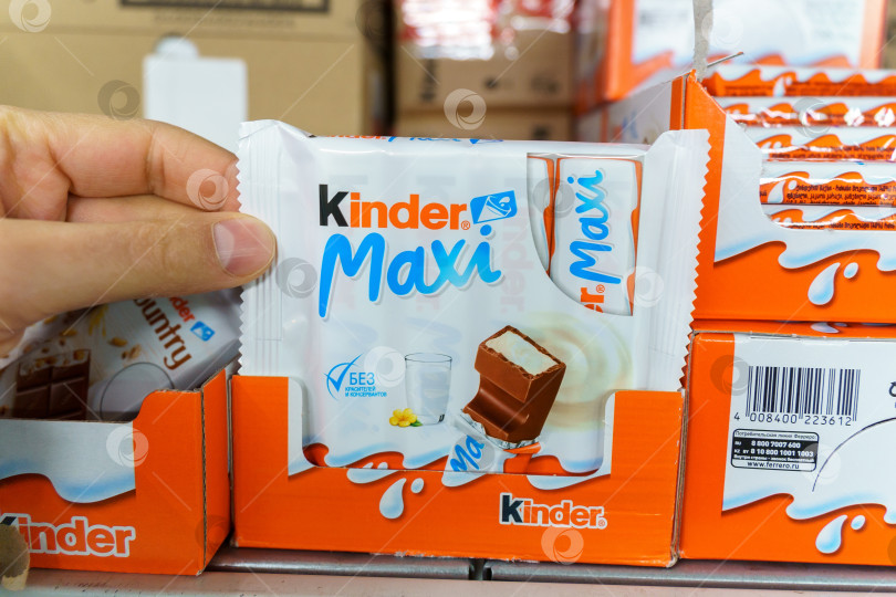 Скачать Тюмень, Россия - 02 декабря 2021 г.: Логотип Kinder Chocolate maxi - линейка продуктов итальянской кондитерской транснациональной корпорации Ferrero. фотосток Ozero