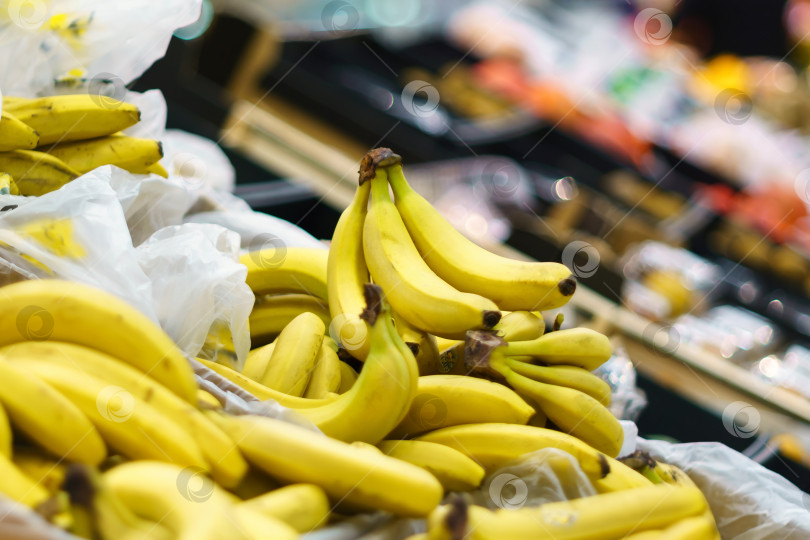 Скачать Желтые бананы на полках продуктового супермаркета. Продажа фруктов фотосток Ozero