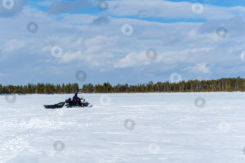 Скачать рыбак на снегоходе катается по зимнему озеру. пейзаж зимнее фото фотосток Ozero