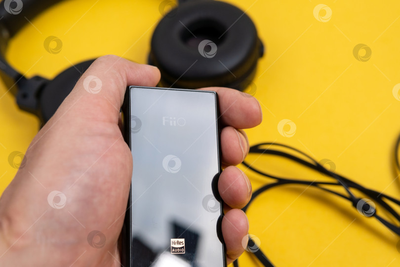 Скачать Тюмень, Россия - 21 июня 2021 года: Проигрыватель Fiio m3 pro для прослушивания музыки с высоким разрешением звука. Желтый фон фотосток Ozero