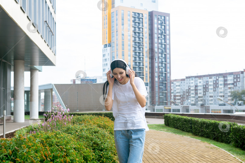 Скачать девушка-подросток наслаждается музыкой в наушниках на открытом воздухе фотосток Ozero