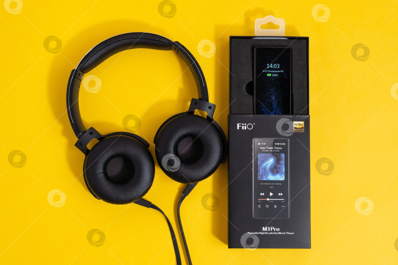 Скачать Тюмень, Россия - 21 июня 2021 года: Проигрыватель Fiio m3 pro для прослушивания музыки с высоким разрешением звука. Желтый фон фотосток Ozero