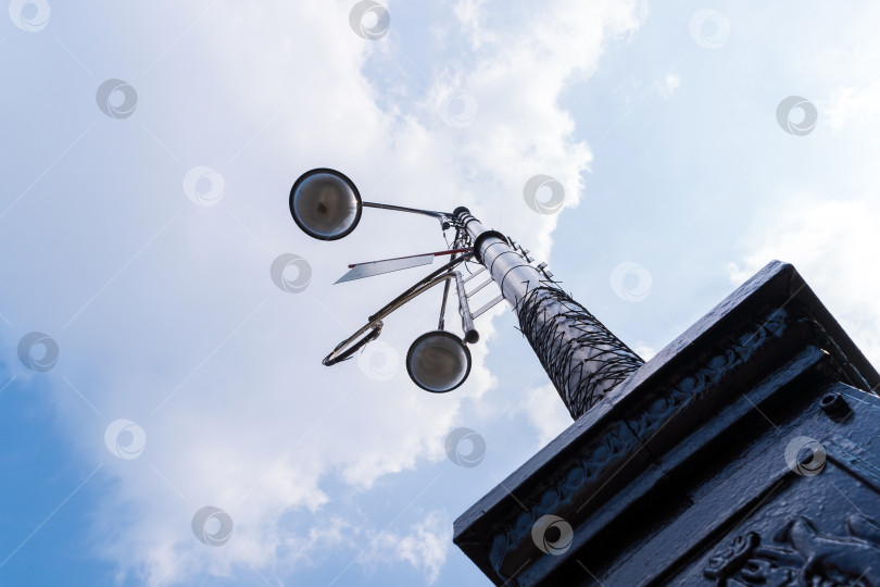 Скачать Старинный железный уличный фонарь крупным планом на фоне голубого неба в солнечный день. фотосток Ozero