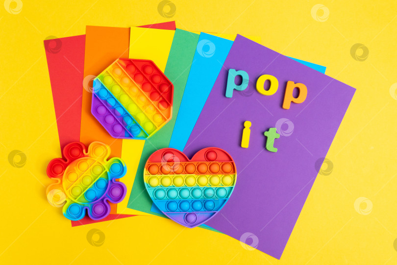 Скачать Красочная антистрессовая игрушка touch pop it. На желтом фоне. Вид сверху фотосток Ozero