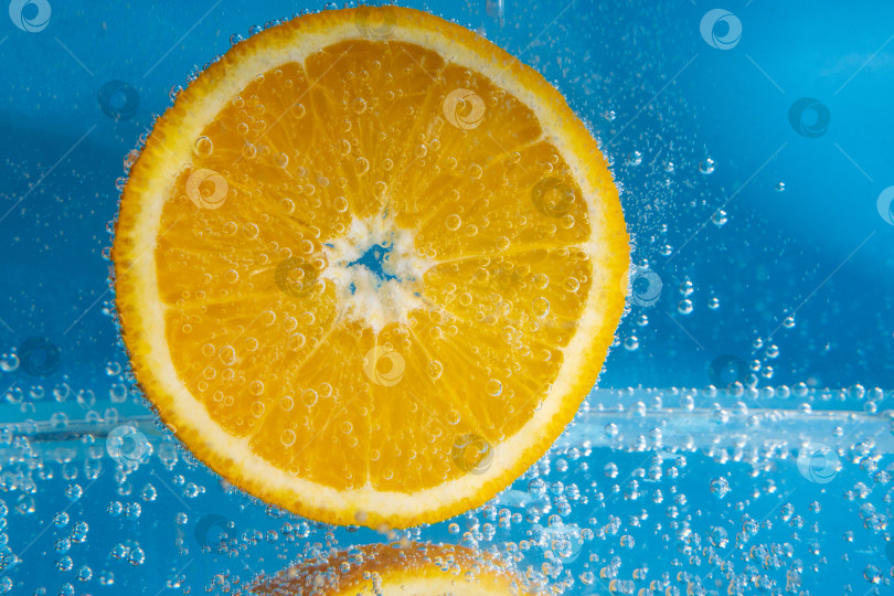 Скачать Апельсиновый фрукт в воде крупным планом, под водой с пузырьками. фотосток Ozero
