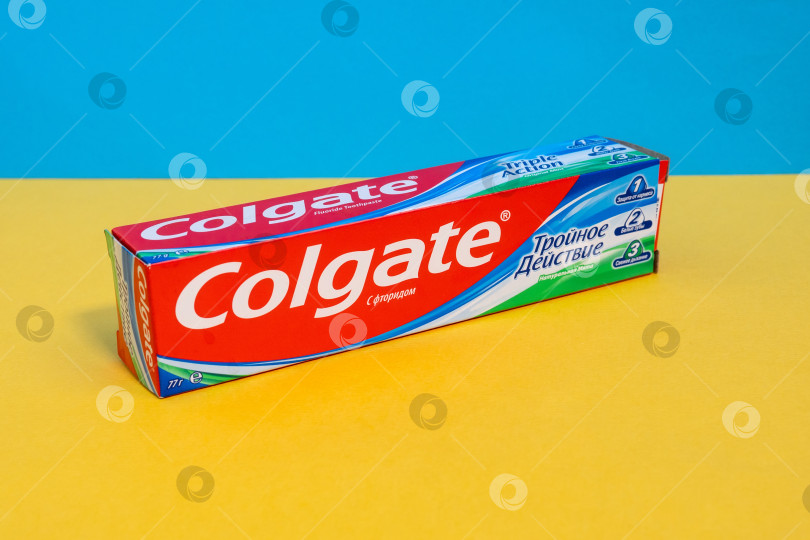 Скачать Тюмень, Россия - 21 июня 2021 года: Отбеливающая зубная паста Colgate Triple Action Extra с кальцием и фтором. Разноцветный фон фотосток Ozero