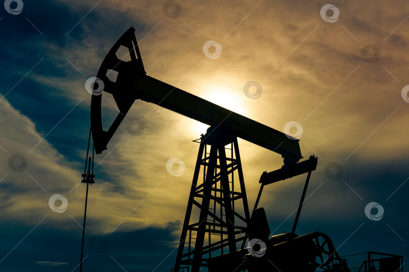 Скачать силуэт насосной станции на нефтяной скважине на фоне тревожного неба фотосток Ozero