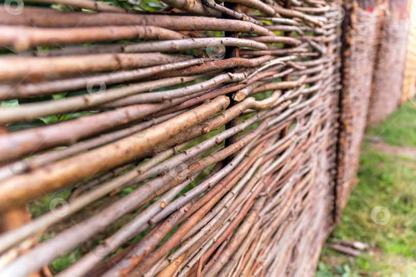 Скачать Забор из сплетенных веток для создания экологически устойчивой стены в саду на заднем дворе. Фон, текстура, элемент декора фотосток Ozero