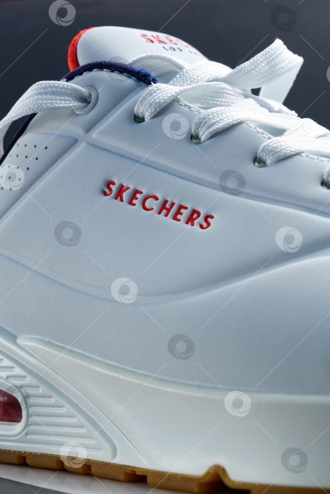 Скачать Тюмень, Россия - 14 октября 2021 года: Обувь Sketchers white Skechers - американская обувная компания. Вертикальная фотография фотосток Ozero