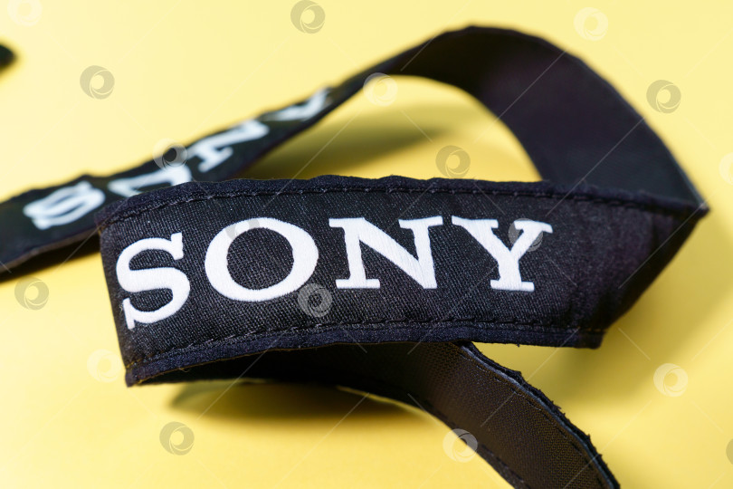 Скачать Тюмень, Россия - 15 октября 2021 года: Логотип компании Sony на ремне беззеркальной камеры на желтом фоне фотосток Ozero