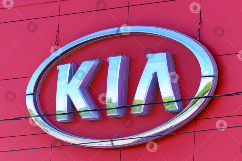 Скачать Тюмень, Россия - 4 июня 2021 года: KIA logo close up Motors - южнокорейская автомобильная компания, производящая легковые автомобили, фургоны и автобусы, принадлежащие Hyundai Motor. фотосток Ozero