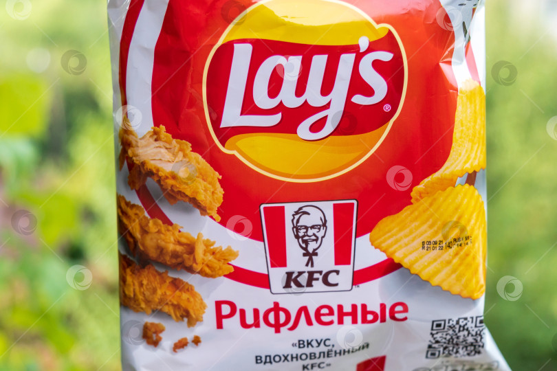 Скачать Волжский, Россия - 25 сентября 2021 года: Lays присоединяется к KFC с новым вкусом. Жареная курица и куриное крылышко. Избирательный фокус фотосток Ozero