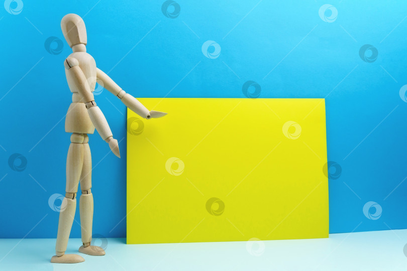 Скачать Деревянный человеческий манекен для разговора или презентации, пустое место для текста. Желтый фон фотосток Ozero