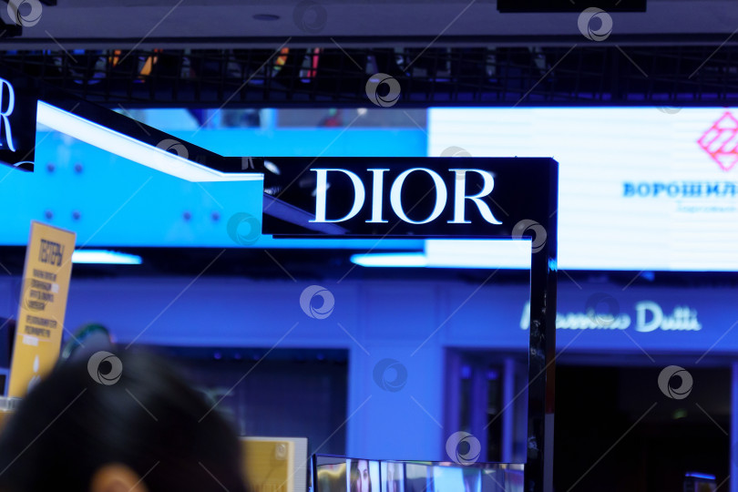 Скачать Волгоград, Россия - 16 сентября 2021 года: Логотип бренда Dior на стене в торговом центре. Избирательный фокус фотосток Ozero