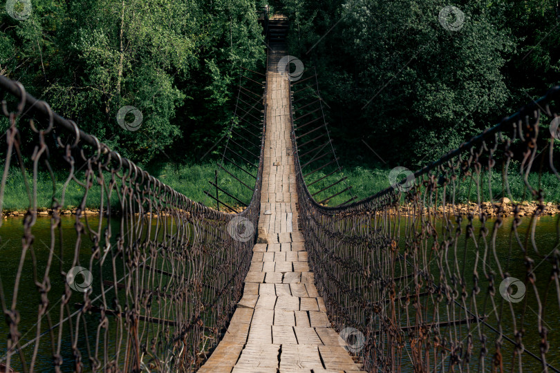 Скачать старый подвесной мост через реку переходит в перспективу фотосток Ozero