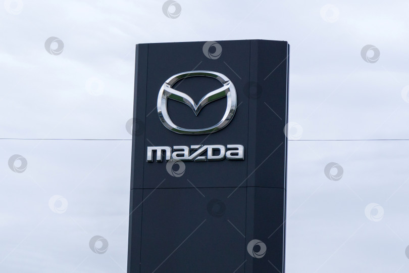 Скачать Волжский, Россия - 25 сентября 2021 года: Центр логотипов Mazda - одного из ведущих производителей автомобилей в Японии. Избирательный фокус фотосток Ozero