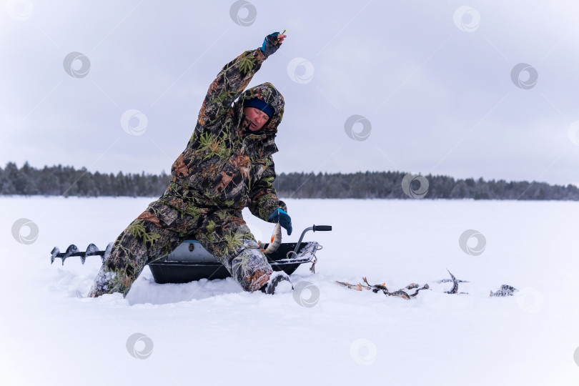 Скачать зимний рыбак на озере ловит окуня на зимней рыбалке. фотосток Ozero