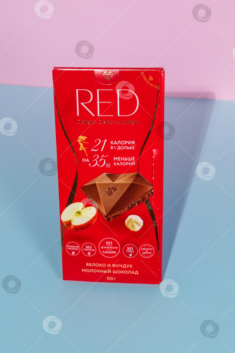 Скачать Тюмень, Россия - 06 августа 2021 года: Красный молочный шоколад с лесными орехами и яблоком. Вертикальная фотография фотосток Ozero