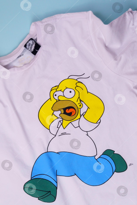 Скачать Тюмень, Россия - 27 августа 2021 года: Симпсоны на футболке Гомера Симпсона. Американский анимационный ситком для взрослых, созданный Мэттом Гренингом. Вертикальная фотография фотосток Ozero