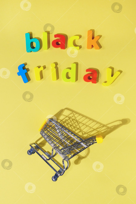 Скачать Надпись black Friday на желтом фоне, вид сверху. Концепция распродажных скидок. Вертикальная фотография фотосток Ozero