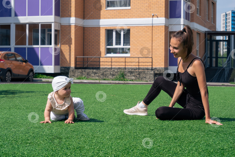 Скачать мать и ребенок гуляют в городском дворе, ребенок пытается встать самостоятельно фотосток Ozero