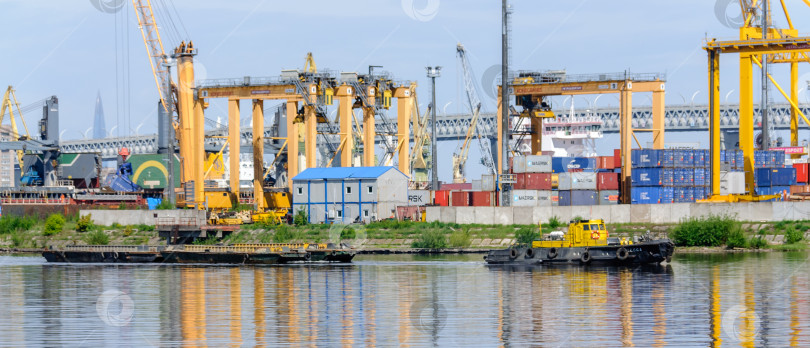 Скачать Россия, Санкт-Петербург, май 2021 года: Морской грузовой порт, краны и суда фотосток Ozero