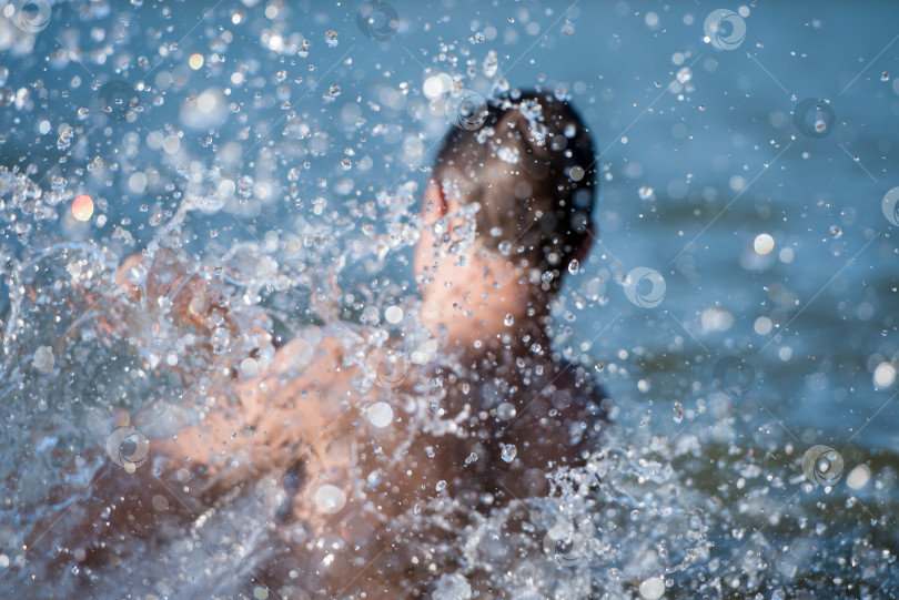 Скачать Мальчик-подросток плавает в брызгах воды - концепция пляжного отдыха фотосток Ozero